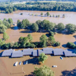 FOX Flood Fallout: Texas Death Toll SOARS Flooded landscape with submerged buildings and vehicles.
