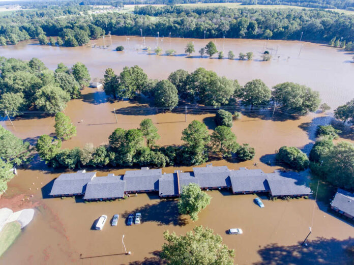 1177328176 Flooded landscape with submerged buildings and vehicles.