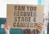 Hands holding cardboard with cancer recovery question