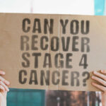 Hands holding cardboard with cancer recovery question