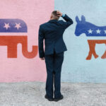 Man deciding between elephant and donkey symbols