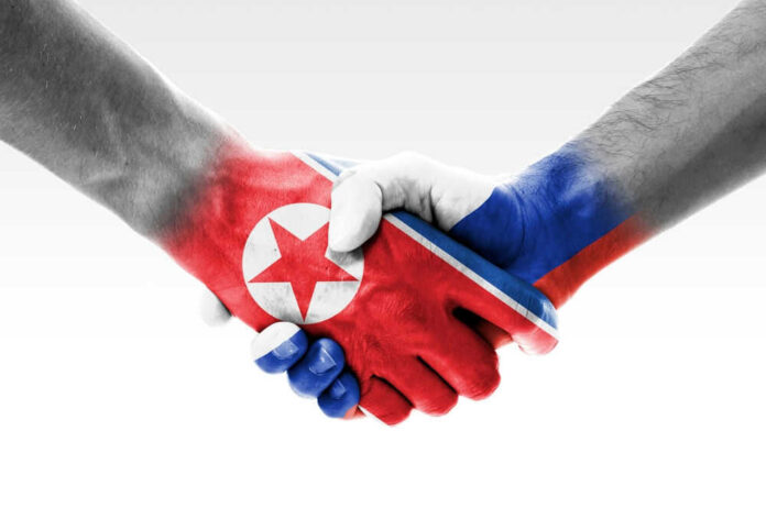 Two hands shaking with flags painted on them.
