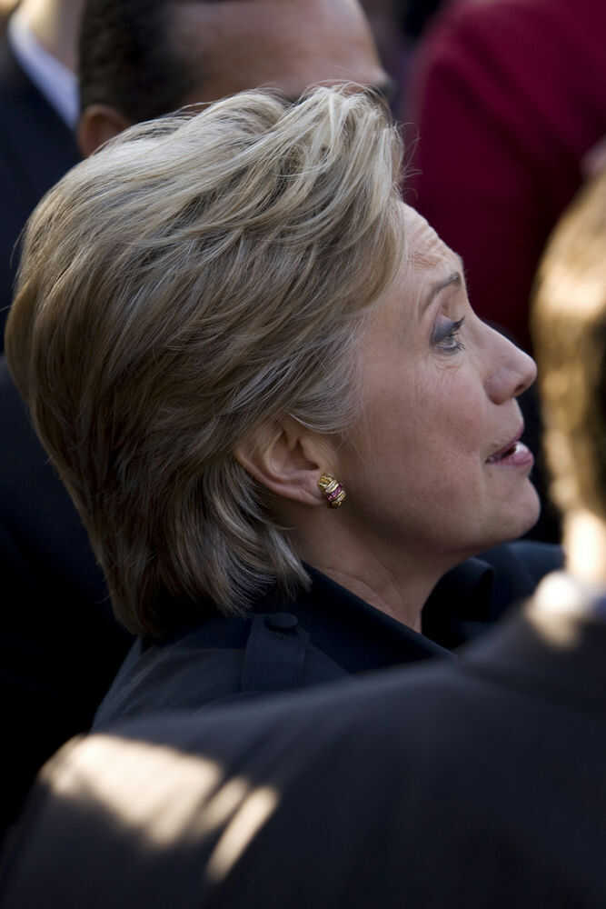 8648599 Person with short blonde hair, wearing gold earrings.