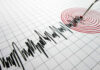 Seismograph needle recording earthquake on graph paper.