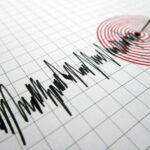 Seismograph needle recording earthquake on graph paper.