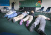 Group of individuals lying on the floor in a classroom during an exercise