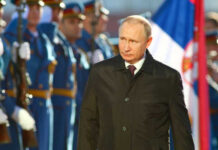 A political figure walking past a military honor guard during a ceremony