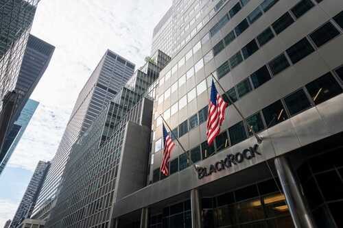 shutterstock_2408537859.jpg View of a modern corporate building with American flags in the financial district