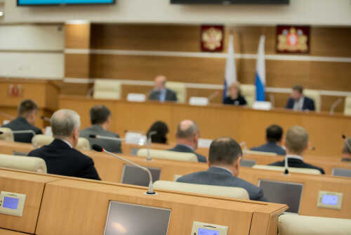 Audience attending a government meeting in a conference room
