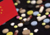 A variety of pills scattered on a surface with a small flag of China