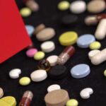 A variety of pills scattered on a surface with a small flag of China