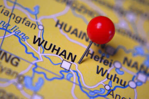 A close-up of a map with a red pin marking the city of Wuhan