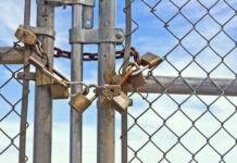 A locked gate secured with multiple padlocks