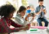 Children engaged in a group activity with electronic devices