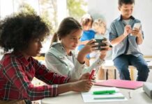 Children engaged in a group activity with electronic devices