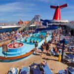 Carnival Cruise Ship Erupted Into Chaos Crowded cruise ship deck with a swimming pool and water slide