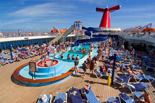 Crowded cruise ship deck with a swimming pool and water slide