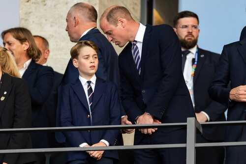 Two individuals in formal attire engaged in conversation at a public event