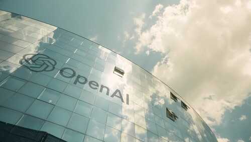 Exterior view of the OpenAI building with a reflective glass facade under a cloudy sky