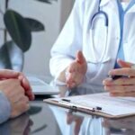 No More Deductibles? New Healthcare Model Stuns Industry A doctor discussing with a patient over a clipboard in a medical office