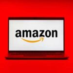 Laptop displaying the Amazon logo on a red background