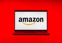 Laptop displaying the Amazon logo on a red background