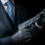 A person in a suit holding a handgun