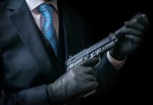 A person in a suit holding a handgun