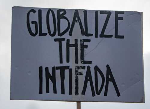 A protest sign that reads 'GLOBALIZE THE INTIFADA' in bold letters