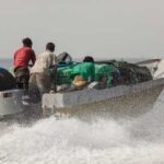 Fishermen on a boat navigating through ocean waves