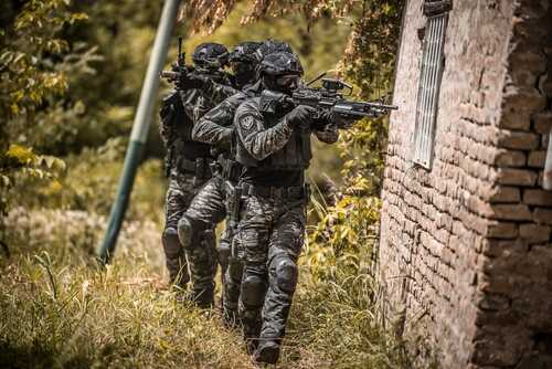 Tactical team in military gear advancing with weapons