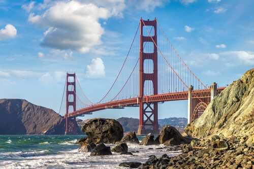 shutterstock_2517041235.jpg Golden Gate Bridge spanning over the water with rocky shoreline in the foreground