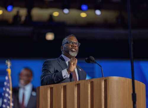 A speaker addressing an audience at a podium during a conference