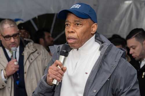 A man speaking into a microphone at an outdoor event