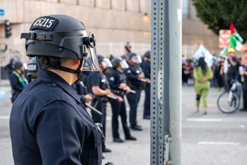Police officers in riot gear monitoring a protest