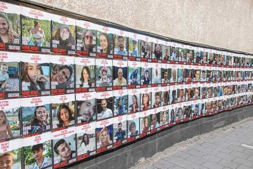 Wall covered with missing persons posters featuring various individuals