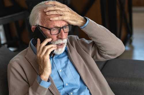 shutterstock_2588019121.jpg Elderly man with glasses talking on the phone, looking concerned