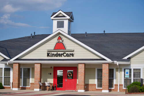shutterstock_1406416601.jpg Exterior view of a KinderCare childcare center with a red door