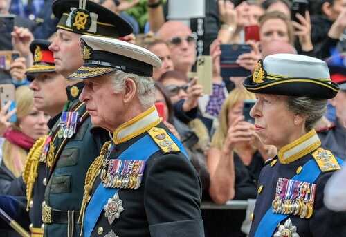 Members of a royal family in military uniforms during a public event