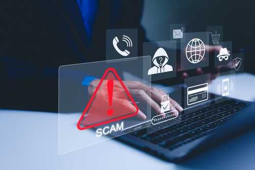 A person using a laptop with scam alert icons displayed