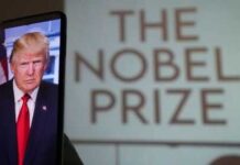 A smartphone displaying a portrait of a political figure with a projection of 'The Nobel Prize' in the background