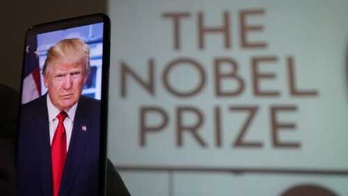 A smartphone displaying a portrait of a political figure with a projection of 'The Nobel Prize' in the background