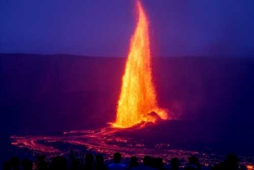 A dramatic volcano eruption with a lava fountain against a dark sky