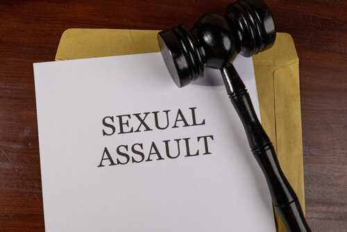 A court gavel resting on a document labeled 'SEXUAL ASSAULT'