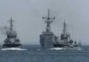 Three naval vessels navigating through the ocean