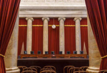 Interior view of a courtroom with red curtains and marble columns