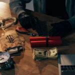 A table with money, a gun, and an explosive device surrounded by tools