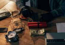 A table with money, a gun, and an explosive device surrounded by tools