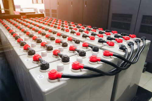 Rows of industrial batteries with red and black terminals