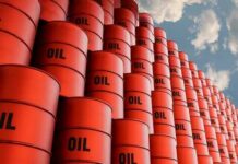 Kharg Island: Could This Tiny Strip Cripple Iran? Stacked red oil barrels against a cloudy sky